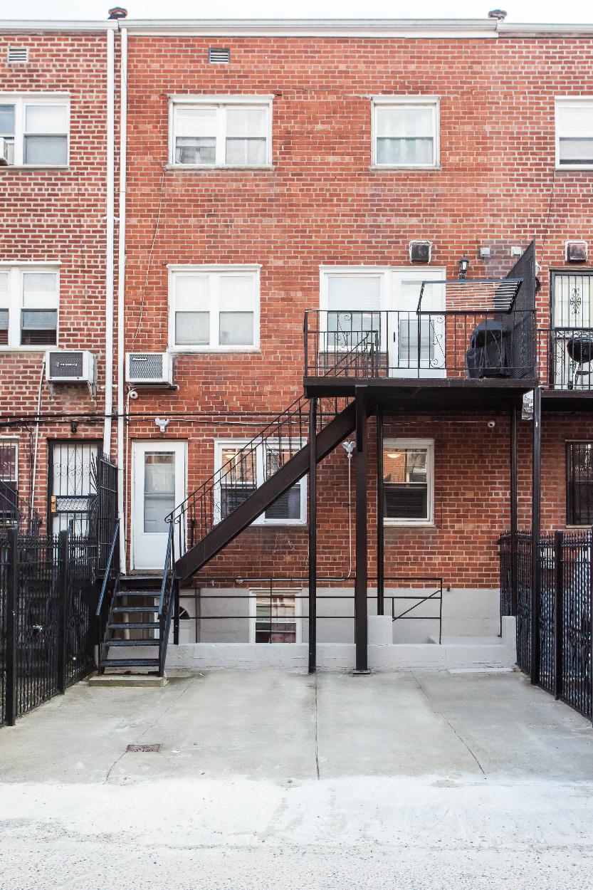 Exterior: Rear of home with 4 floors and fenced driveway/ backyard