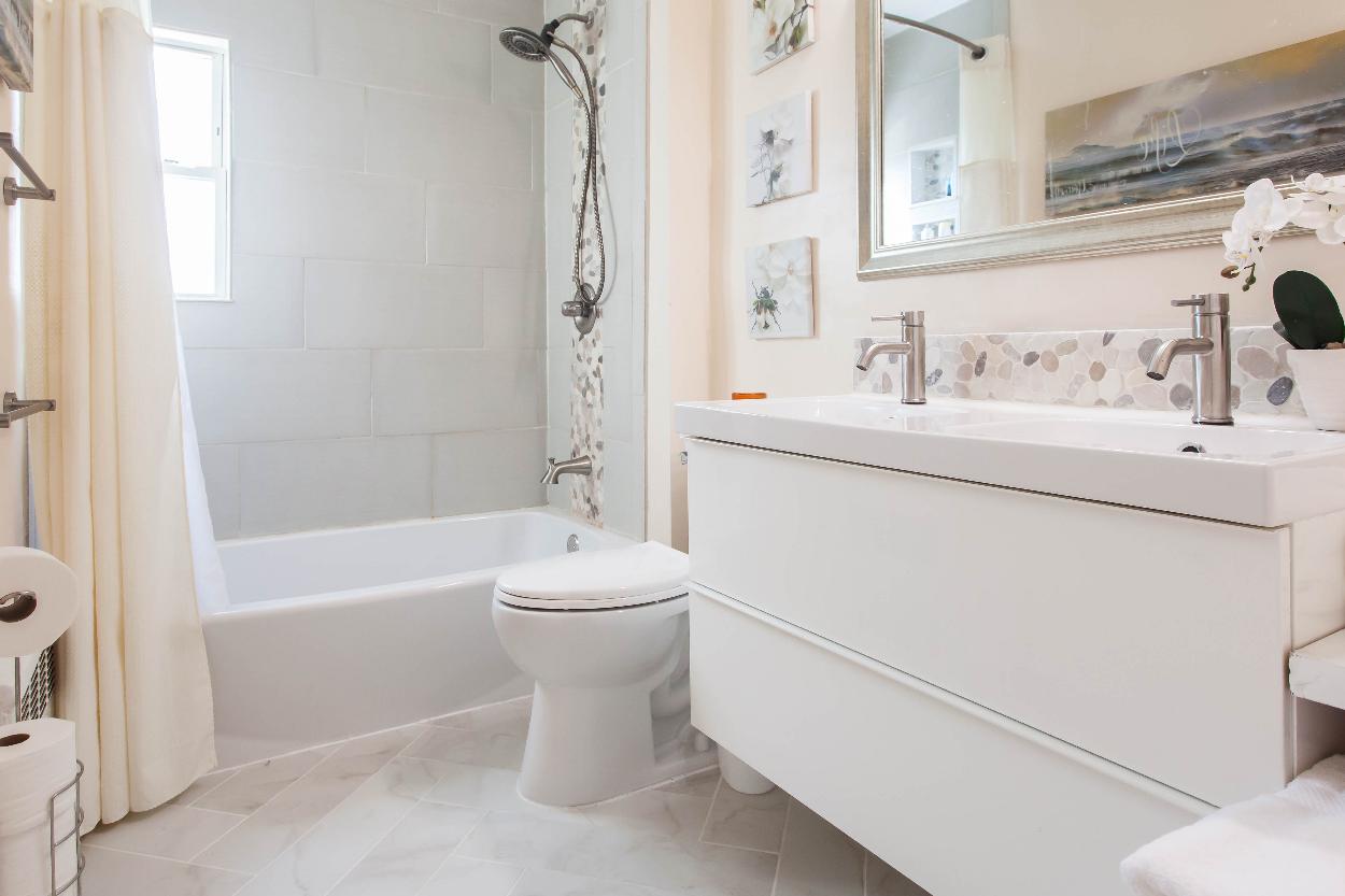 Third Floor: Modern full bathroom with floating double sink vanity + storage, extra wide shower/tub